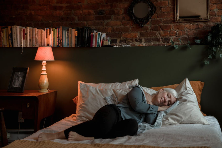 Older woman sleeping peacefully in a warm, cosy bedroom