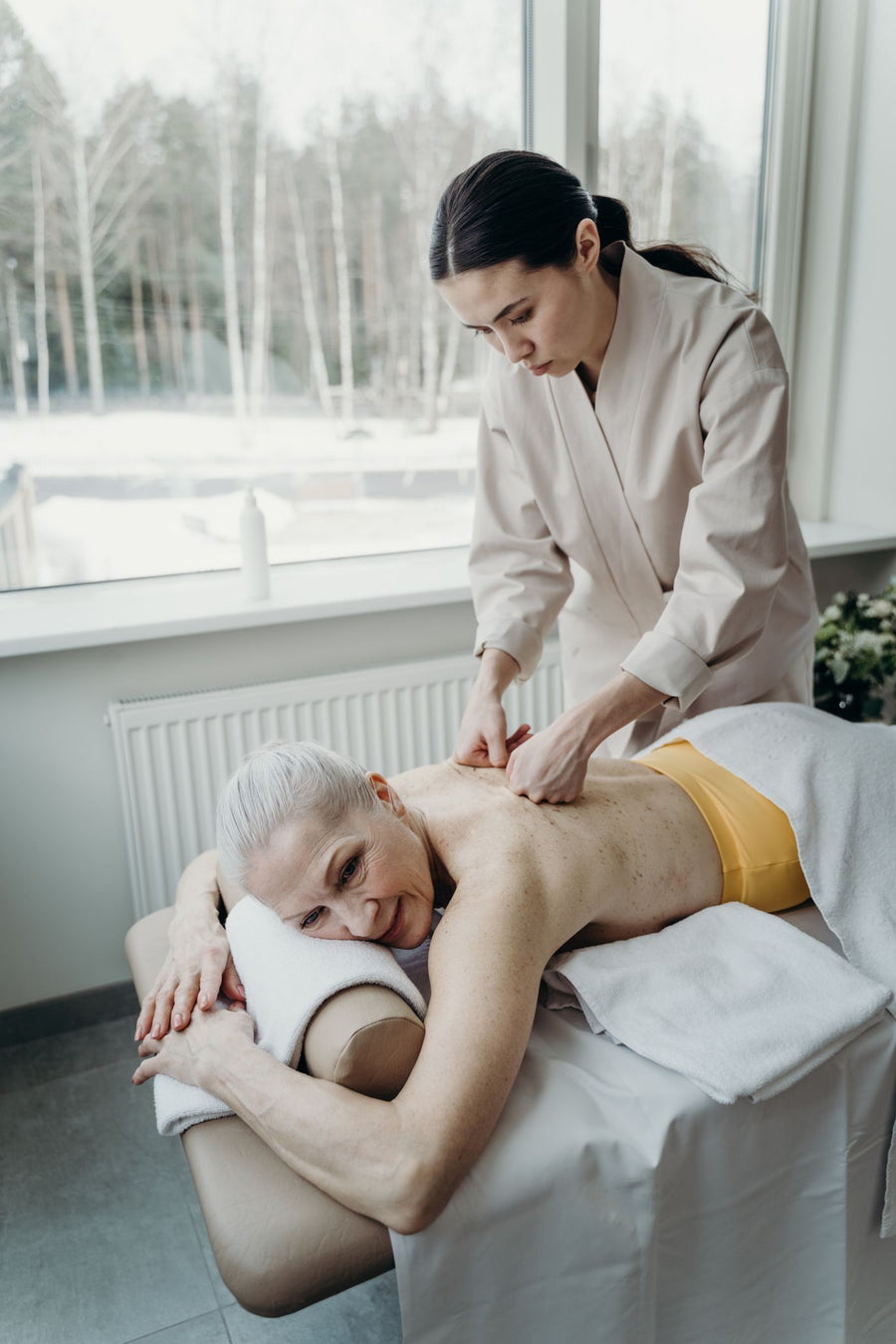 Older woman smiling while receiving a gentle back massage